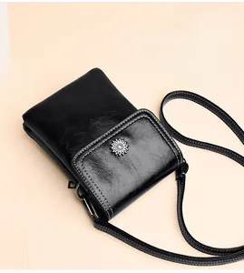 Close-up of black PU leather phone bag featuring contrast stitching and sunflower metal clasp