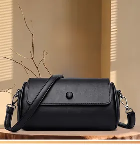 Détail d'un sac bandoulière en cuir noir minimaliste avec rabat et boucle argentée