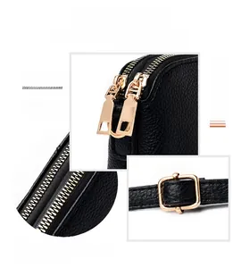 Close-up of polished gold-tone hardware and lychee grain leather texture on a black bag
