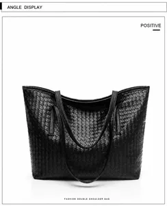 Detailed view of black woven texture on large synthetic leather tote bag with slim straps