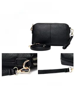Detail of black lychee grain leather handbag with gold hardware and removable straps