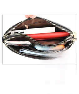Detail of black pebbled leather crossbody bag with dual zippers and rear safety pocket