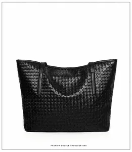 Reverse side view of a black woven leather tote bag with classic intrecciato texture