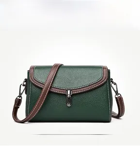 Close-up of green lychee leather handbag with brown trim and white stitching details