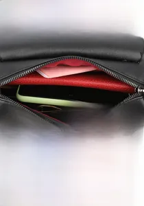 Détail du sac cylindre en cuir grainé noir montrant l'intérieur spacieux et le fermoir aimanté