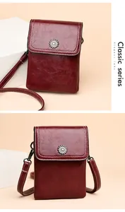 Detail of burgundy crossbody phone bag with sunflower metal hardware and white stitching