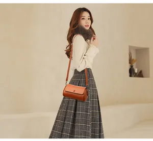 Sac cylindrique en cuir souple marron avec rabat et boucles en métal doré délicates