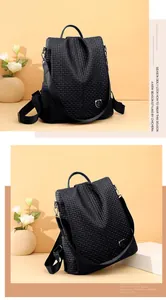 Detail view of black woven texture backpack with metal shield logo and side metal buckles