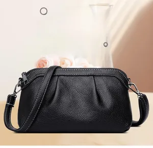 Close-up of black lychee grain leather crossbody bag with elegant pleated texture detail