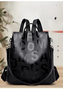 Detailed view of black litchi grain leather backpack with embossed letter design