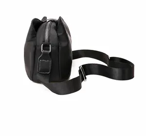 Vista laterale dello zaino moda in nylon nero con cerniere argento e tracolla larga