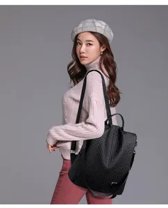 Detail of woven texture and premium leather handles on a black women backpack