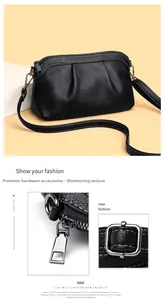Macro shot of silver metal zipper and adjustable strap buckle on black leather crossbody bag