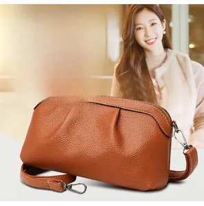 Detail of caramel lychee grain leather crossbody bag with pleated front and silver hooks