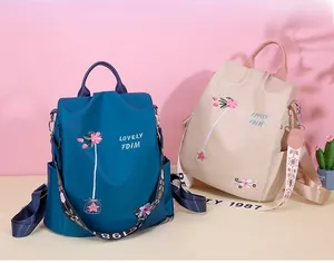 Detail of embroidered floral patterns on blue and beige oxford fabric backpacks