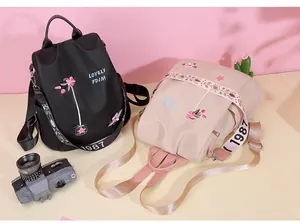 Detail of floral embroidery and colorful patterned straps on dual stylish backpacks