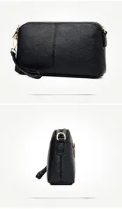 Detail view of black lychee grain texture and gold hardware on stylish crossbody bag