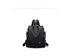 Macro detail of the woven texture and silver shield logo on a black backpack