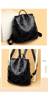 Detail of black leather backpack with embossed letters and adjustable straps