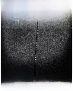 Detail of black lychee grain leather handbag with stylish white contrast stitching