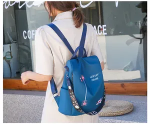 Detail of floral embroidery and ethnic woven strap on a navy blue waterproof backpack