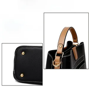Detail of durable gold hardware and white stitching on a black lychee leather bucket bag