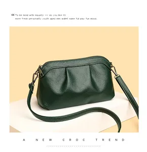 Detailed macro view of dark green pebbled leather texture and adjustable shoulder strap buckle