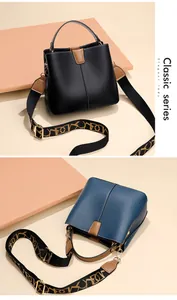 Detail view of leather bucket bags with wide jacquard straps and gold hardware