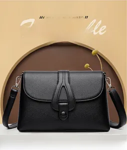 Détail du sac à main en cuir grainé noir avec lanière décorative en forme de larme