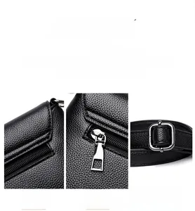 Gros plan sur un sac bandoulière en cuir noir avec zips argentés et sangle réglable en métal