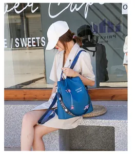 Detail of floral embroidery and colorful printed strap on the blue oxford backpack