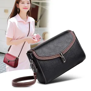 Chic black and brown leather crossbody bag with white stitching shown in outdoor and studio view