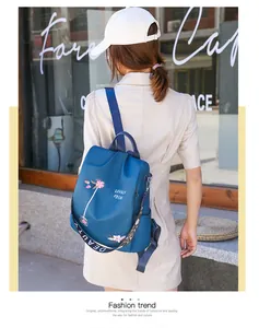 Detail of blue oxford fabric backpack featuring floral embroidery and chic jacquard strap