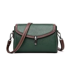 Dark green pebble leather crossbody bag with brown trim and contrast stitching details