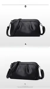 Detail of black pebbled leather crossbody bag with white contrast stitching and silver hardware