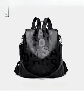 Detailed front view of black leather backpack with 3D embossed lettering and lychee texture