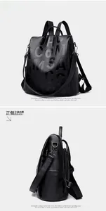 Macro detail of black pebble leather backpack featuring stylish white letter print
