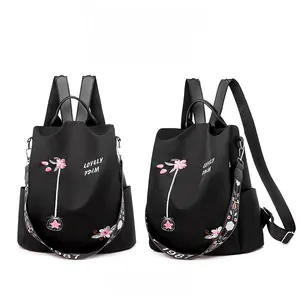 Detail of black oxford backpack featuring floral embroidery and patterned shoulder straps