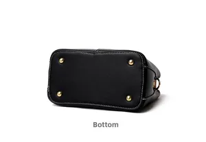 Detail view of the black pebble leather handbag bottom with gold protective metal feet