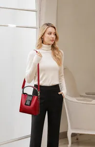 Red pebbled leather bucket bag styled by a model with a casual white sweater outfit