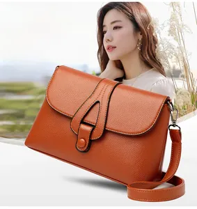 Détail du sac bandoulière orange vintage avec texture cuir grainé et boucle triangulaire