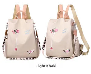 Detail of light khaki backpack with floral embroidery and branded woven shoulder strap