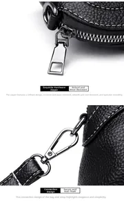 Detail of black lychee grain leather crossbody bag with silver zipper and metal buckle