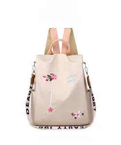 Front view of beige nylon backpack with floral embroidery and adjustable pink straps