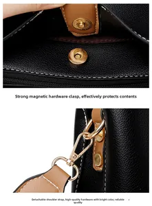 Close-up of golden magnetic snap and detachable strap hardware on black leather bag