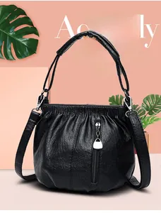 Detail of black ruched handbag with silver hardware and detachable shoulder strap