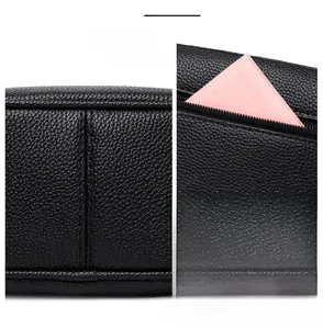 Close-up of black lychee grain leather crossbody bag showing fine stitching and back zipper pocket