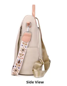 Side view of beige nylon backpack with floral embroidered strap and open pocket