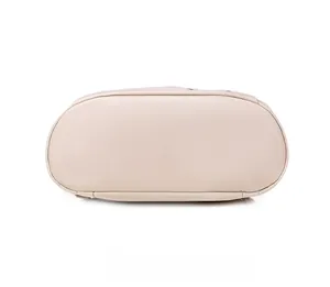 Detail view of the wide oval bottom structure and reinforced stitching of the beige backpack