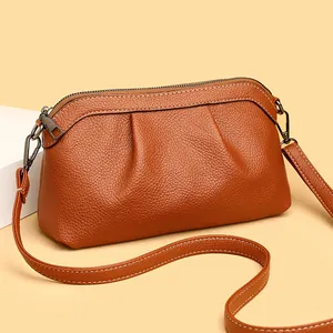 Caramel brown pebbled leather crossbody bag with pleated detail and metal zipper closure